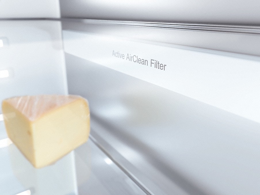 Active AirClean Filter neben einem dreieckigen Käsestück in einem Miele Mastercool Kühlschrank