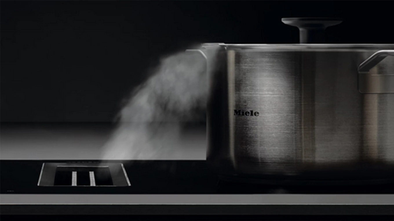 Miele Topfset Dampf wird von einem Miele Topf direkt in den Abzug im Kochfeld geführt