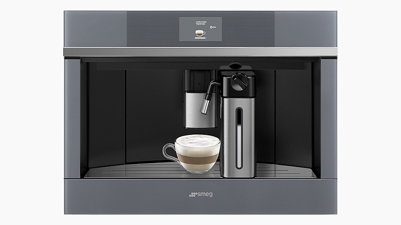 Smeg Einbau Kaffeevollautomat in grau mit einem kleinen kaffeeglas in dem latte macchiato gefüllt ist