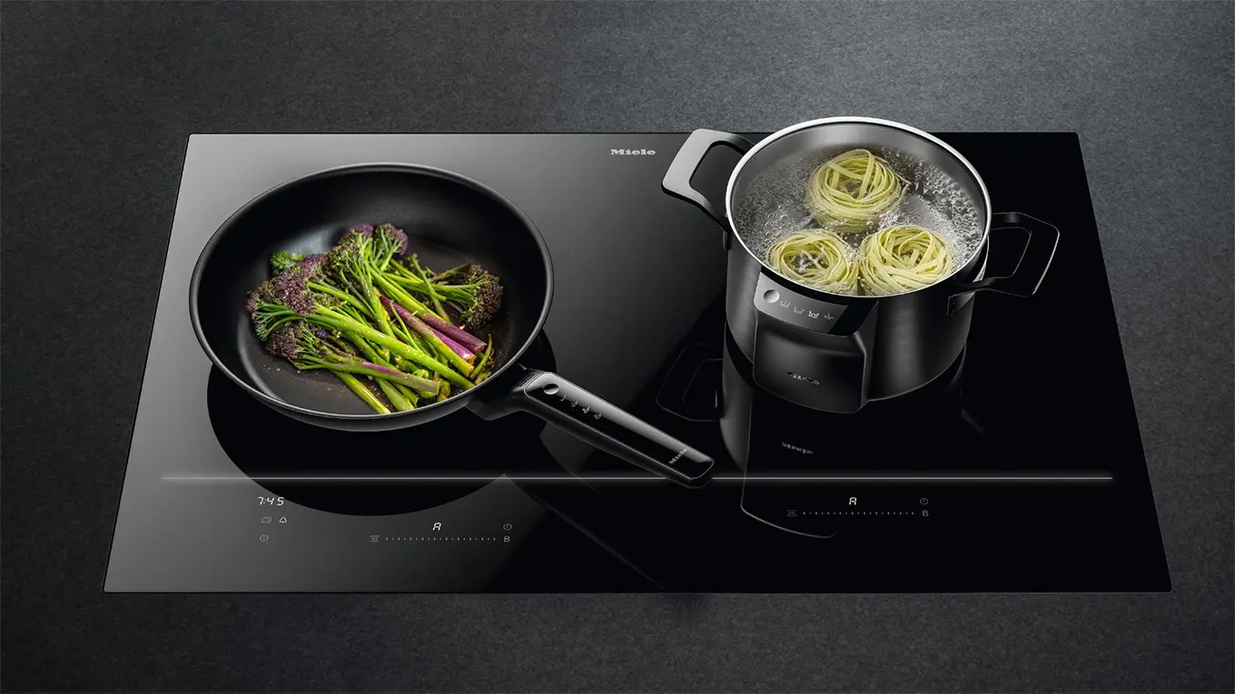 Pfanne und Topf mit speisen auf dem miele km 8885 diamondfinish kochfeld