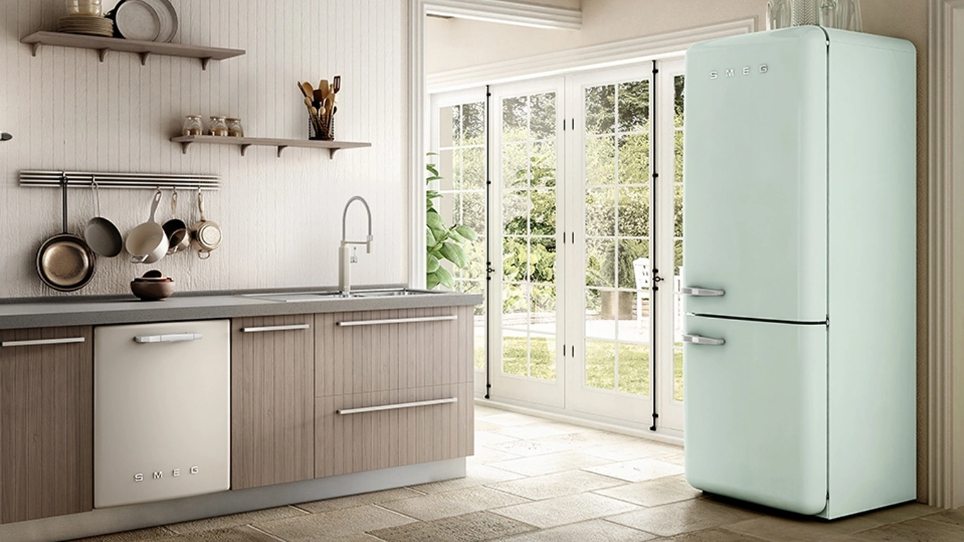 retro kühlschrank-gefrierkombination in pastellgrün von smeg in einer klassischen küche
