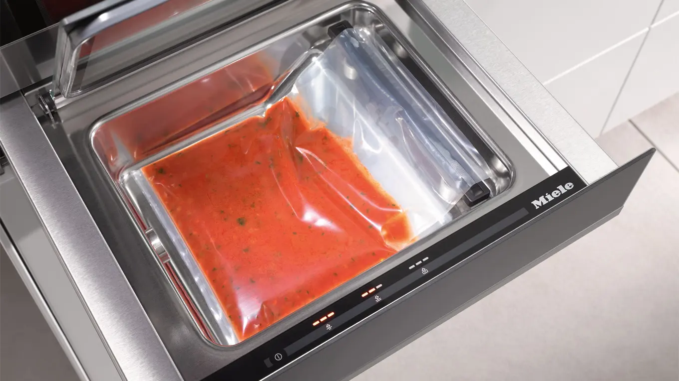 rote soße mit kräutern im vakuumbeutel in einer miele vakuumierschublade