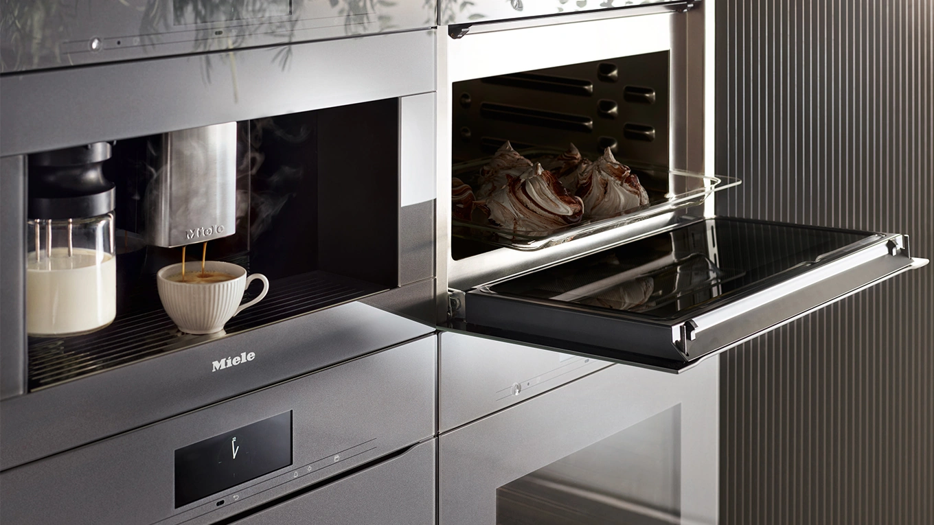 miele einbau kaffeevollautomat & backofen miele einbau kaffeevollautomat mit tasse neben einem backofen in grau