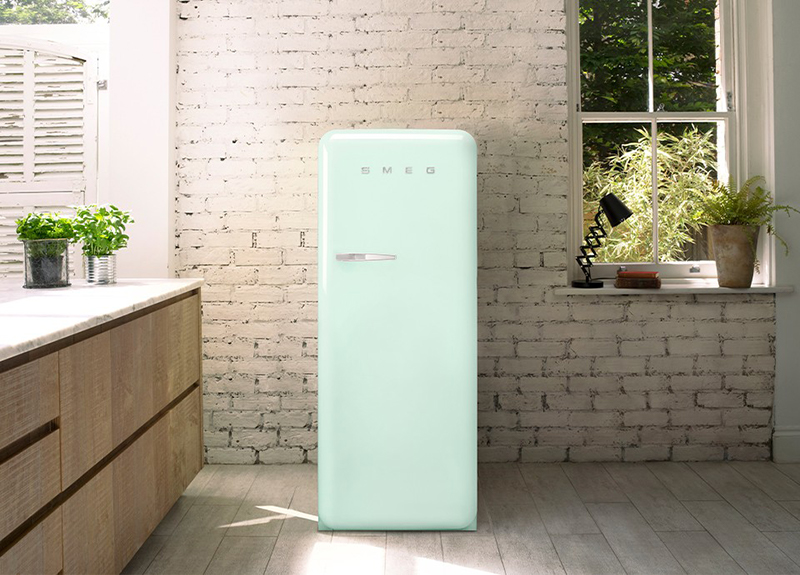 pastellgrüner smeg retro kühlschrank von vorne in einer holzküche