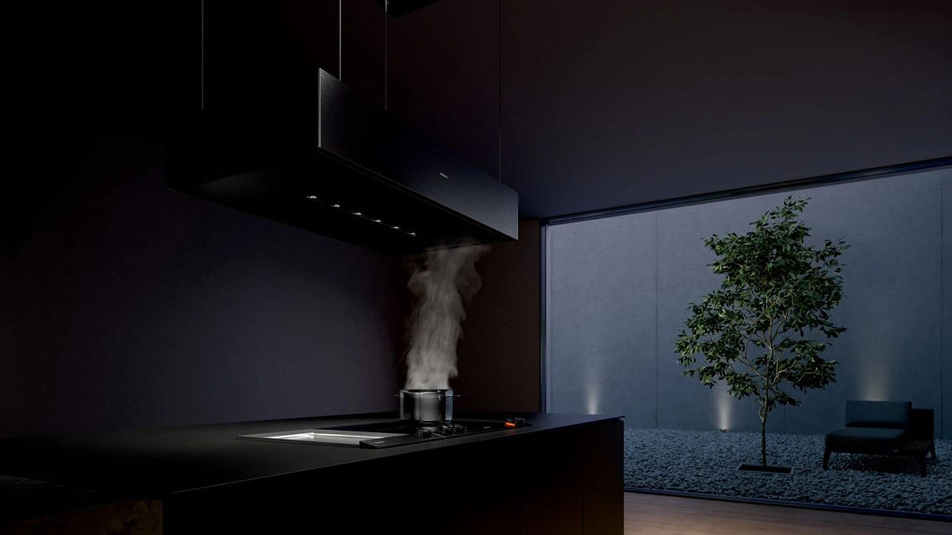 gaggenau deckenlifthaube aus der serie 200 über dem Kochfeld in einer dunklen Küche bei Nacht