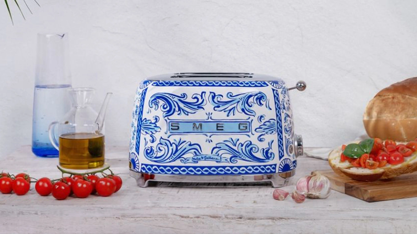smeg dolce & gabbana blue mediterraneo toaster in blau-weiß neben tomaten und öl