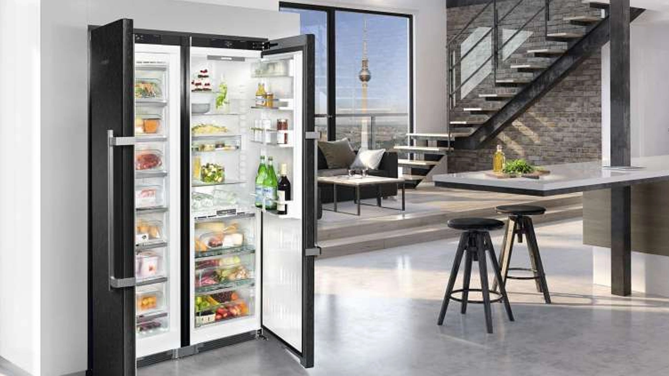 voller schwarzer side by side kühlschrank SBSbs 8683 von liebherr mit geöffneter tür in einer modernen wohnküche