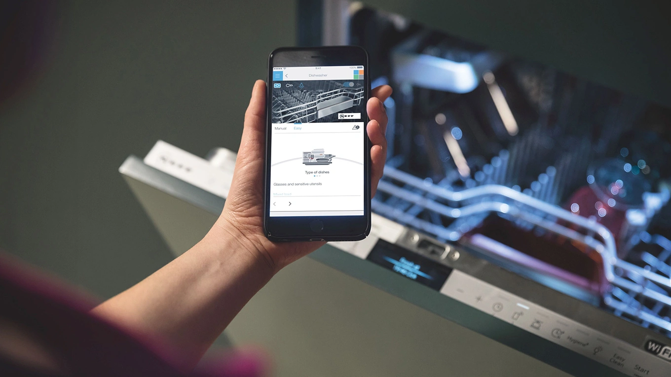 Neff Home Connect Geschirrspüler Smartphone vor einem geöffneten neff home connect geschirrspüler