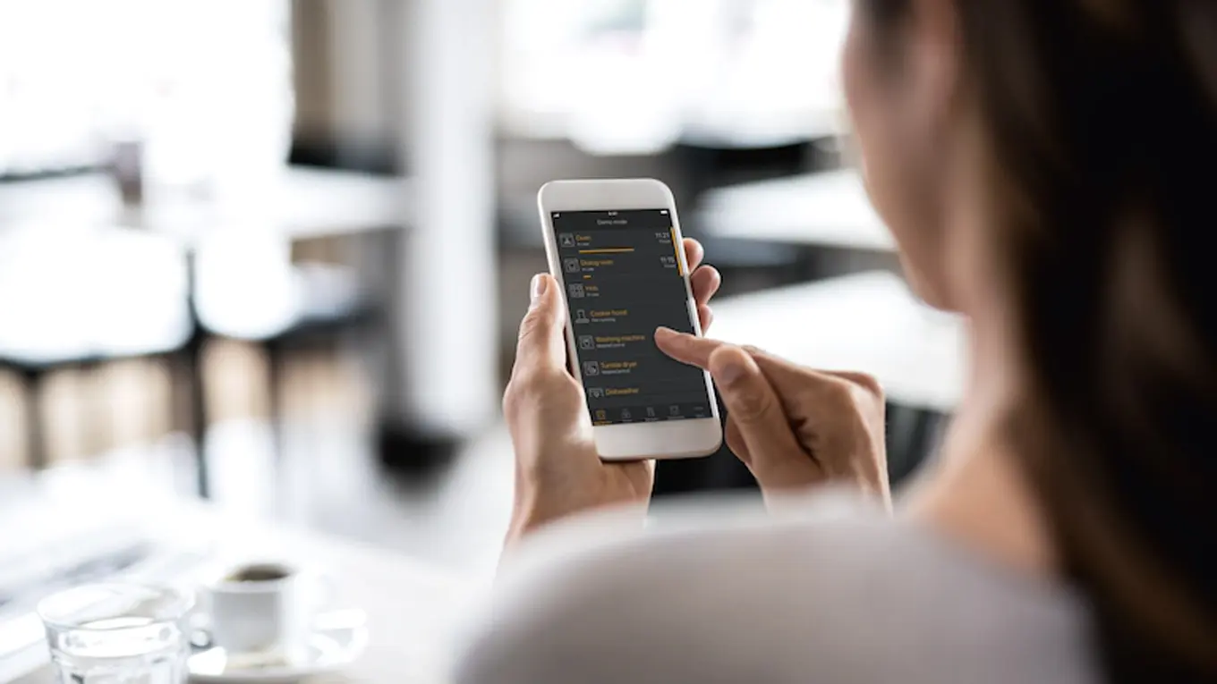 frau mit smartphone für kaffee bedienung mit der miele app