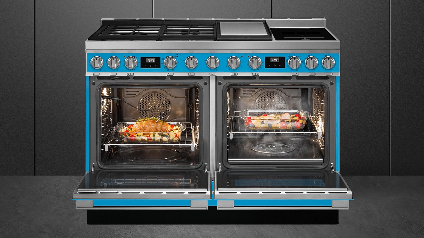SMEG Portofino Doppelbackofen mit zwei Türen smeg portofino herd in blau mit zwei geöffneten backöfen in einer schwarzen kulisse