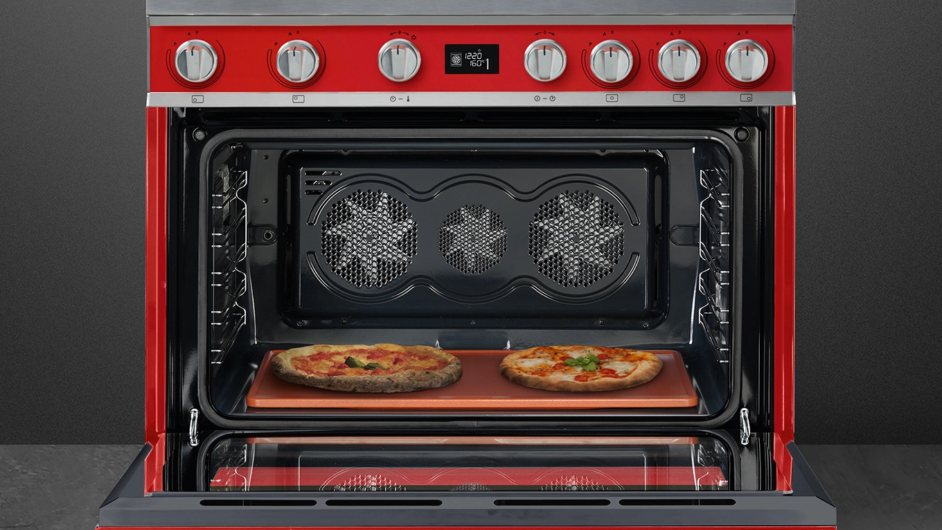geöffneter smeg portofino range cooker in rot mit zwei Pizzen im Backraum