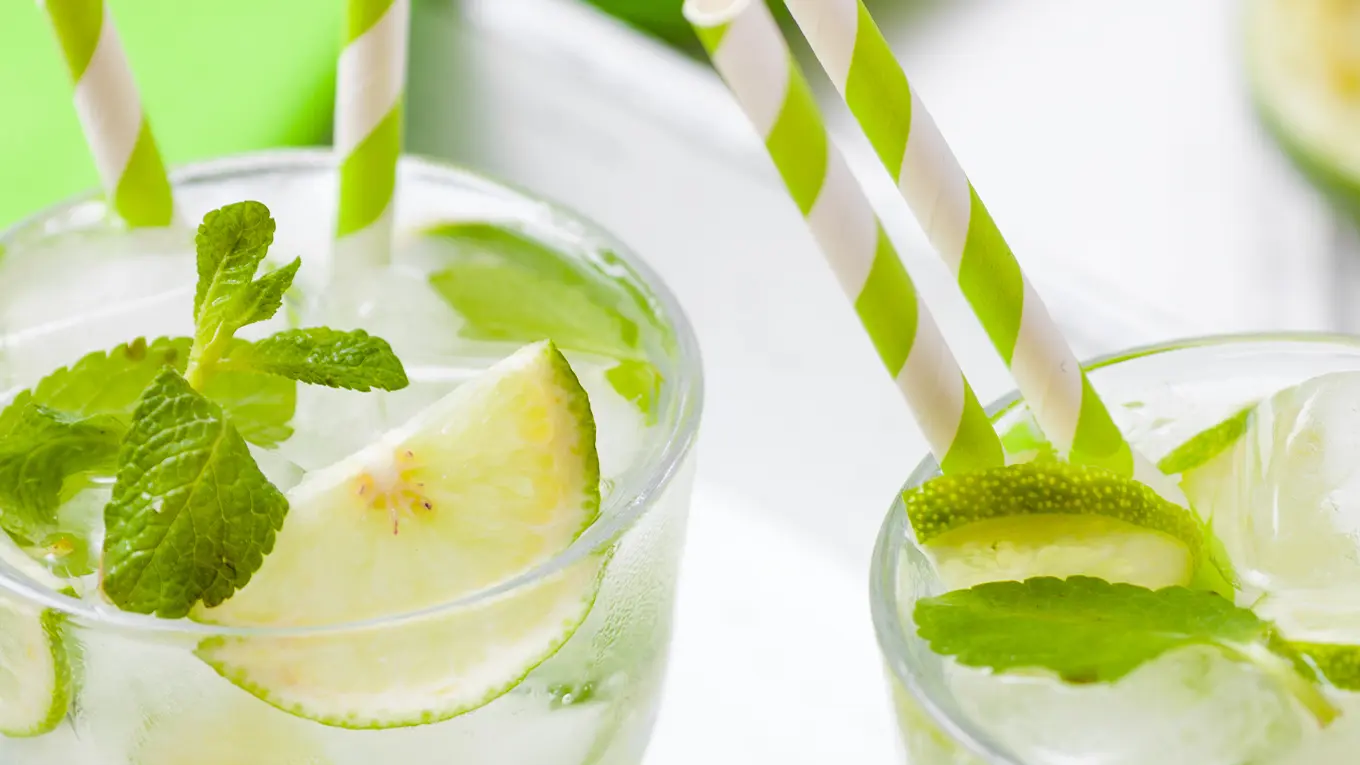 Detail vom Vodka Lemon Cocktail mit minze limette und farblich passenden Strohhalmen