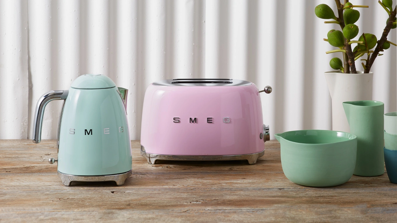 smeg wasserkocher und toaster in blau und pink auf einer arbeitsplatte neben vasen