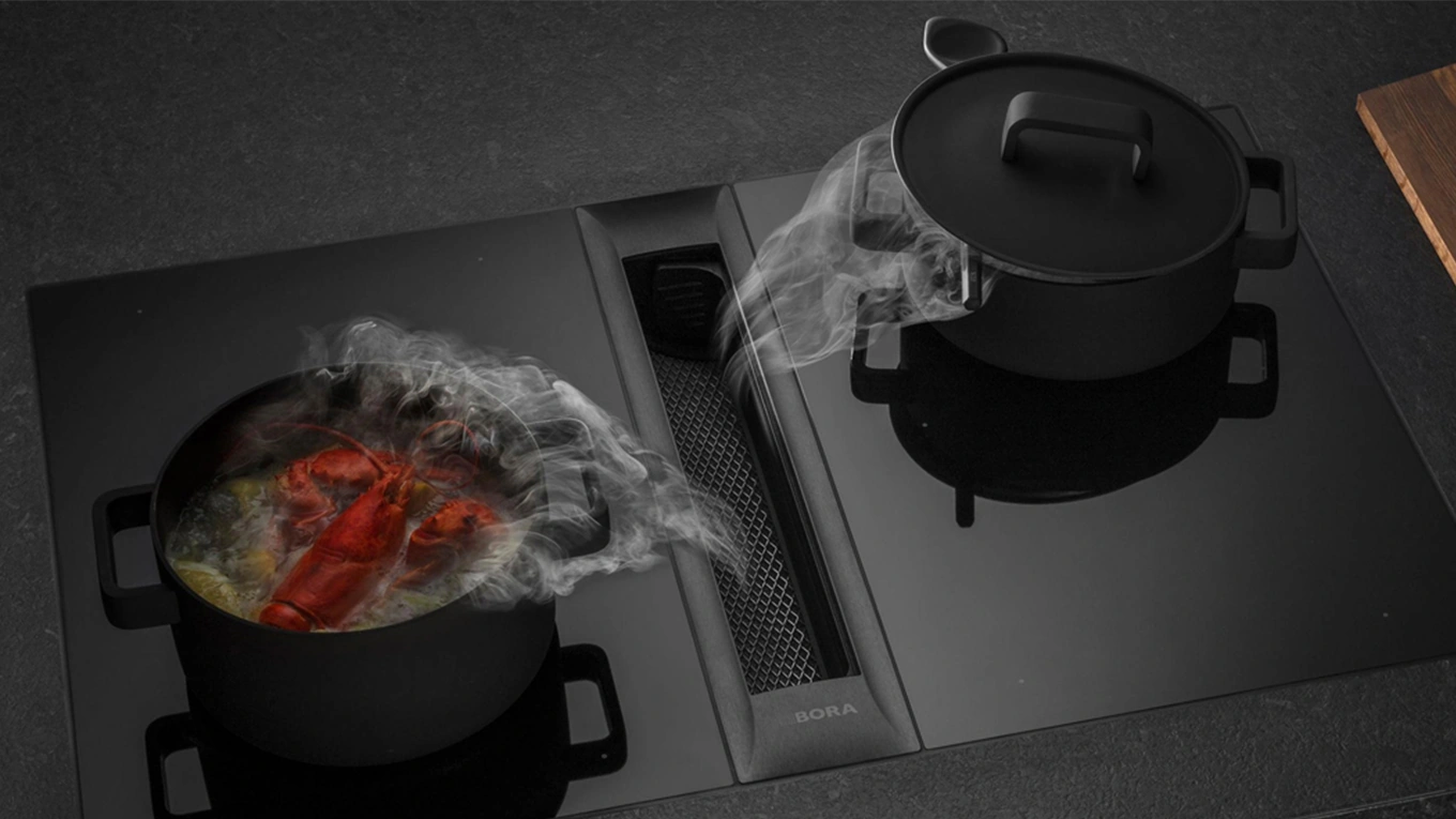 BORA Professional Kochfeld mit Dunstabzug bora professional kochfeld in dunkler kulisse wie der abzug dunst am kochfeld absaugt