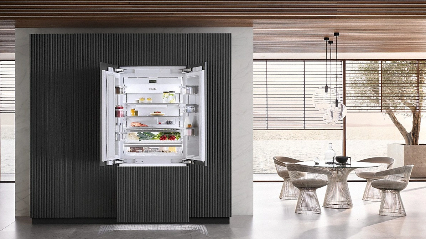 miele side by side kühlschrank mastercool gefüllter miele side by side kühlschrank aus der reihe mastercool mit geöffneten french door türen in einer offenen wohnküche neben einem runden esstisch