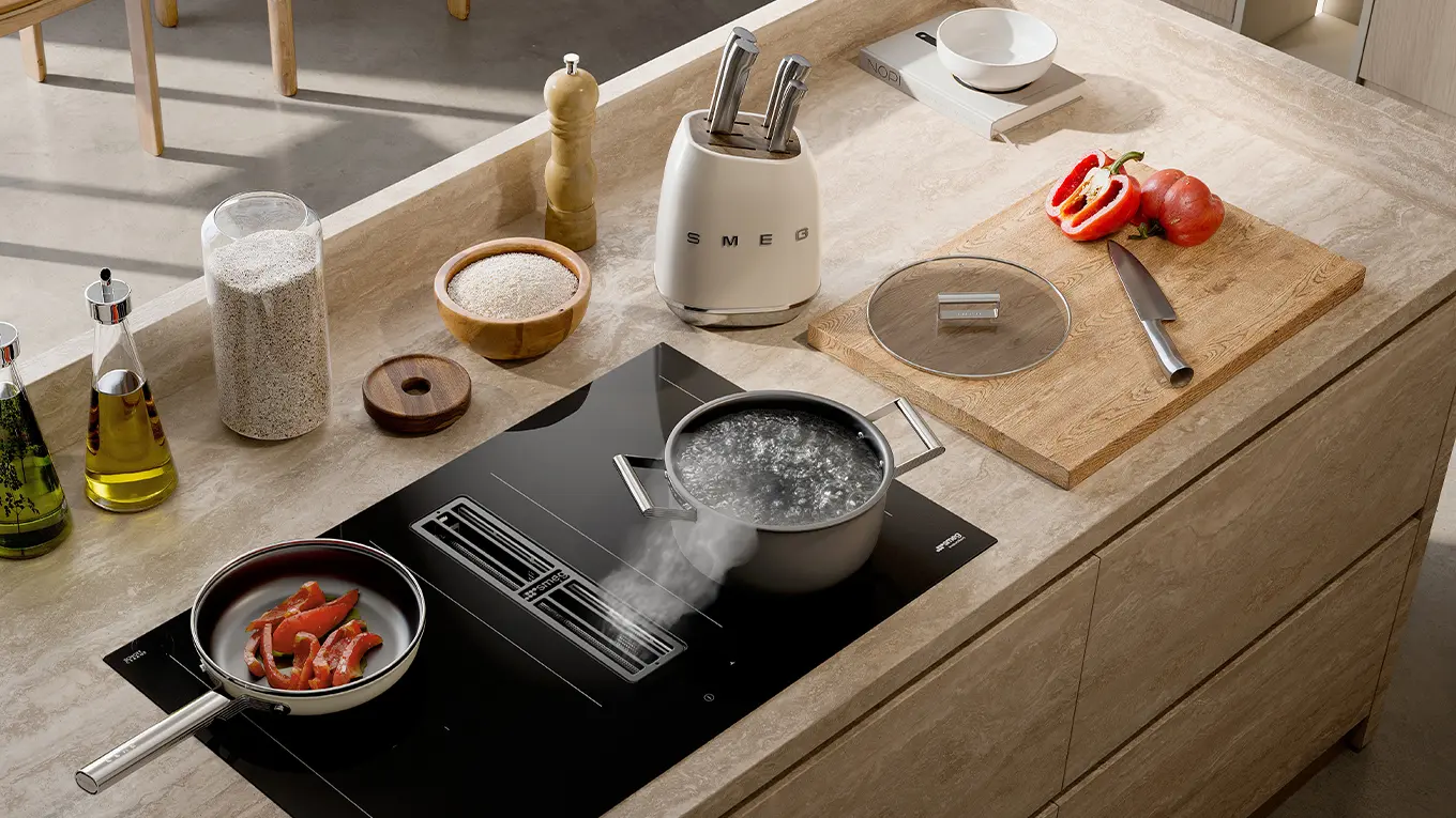 Speisen in topf und pfanne auf einem smeg kochfeld mit dunstabzug