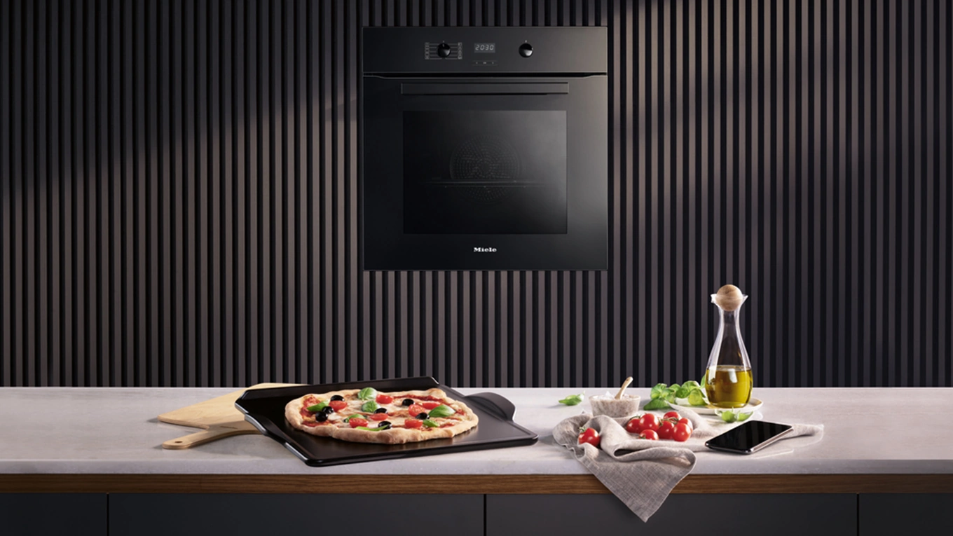 Miele Pizzastein pizza auf dem miele backstein auf einer arbeitsplatte vor dem miele pizzaplus backofen