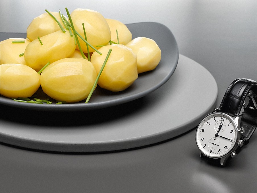 Kartoffeln mit Schnittlauch auf einem grauen teller neben einer schwarzen Armbanduhr