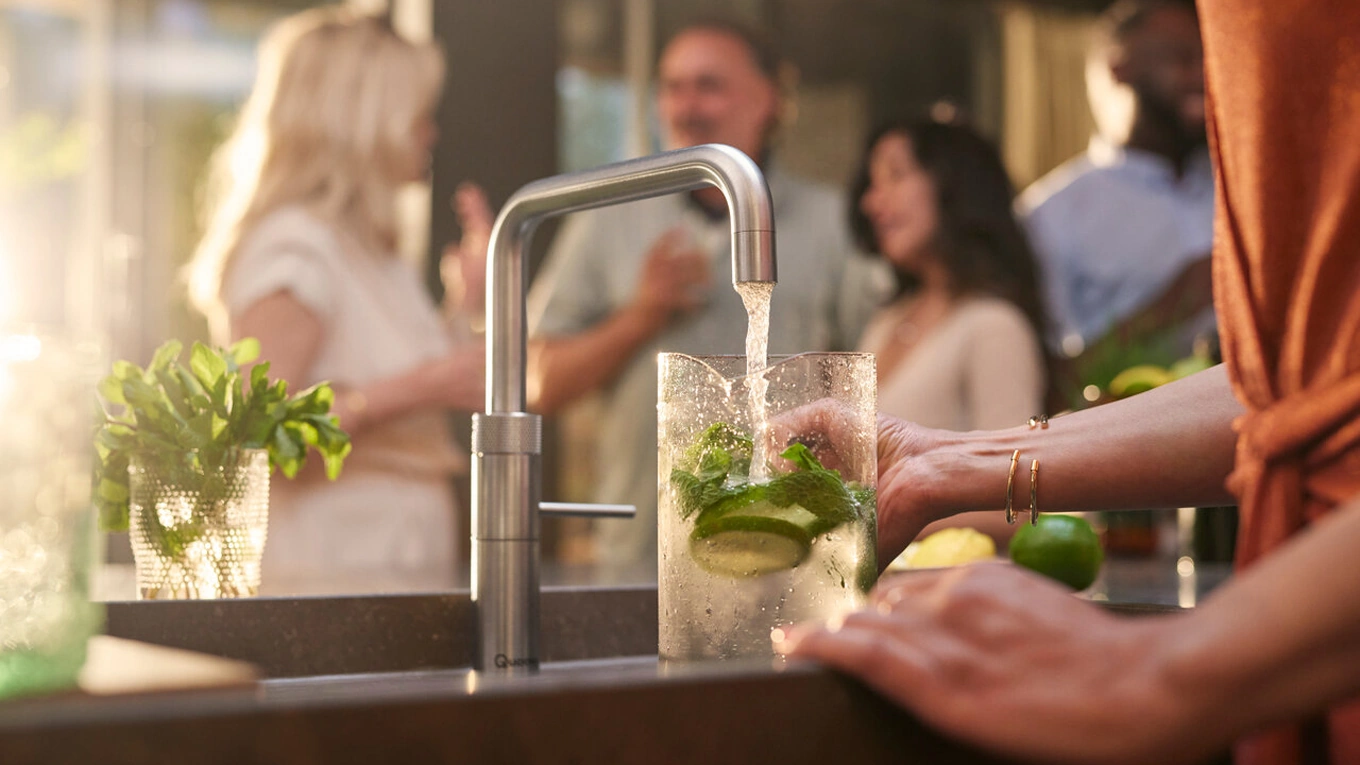 Quooker Sprudelwasser Kaltes sprudelwasser aus einem quooker edelstahl wasserhahn wird in eine glas karaffe gefüllt