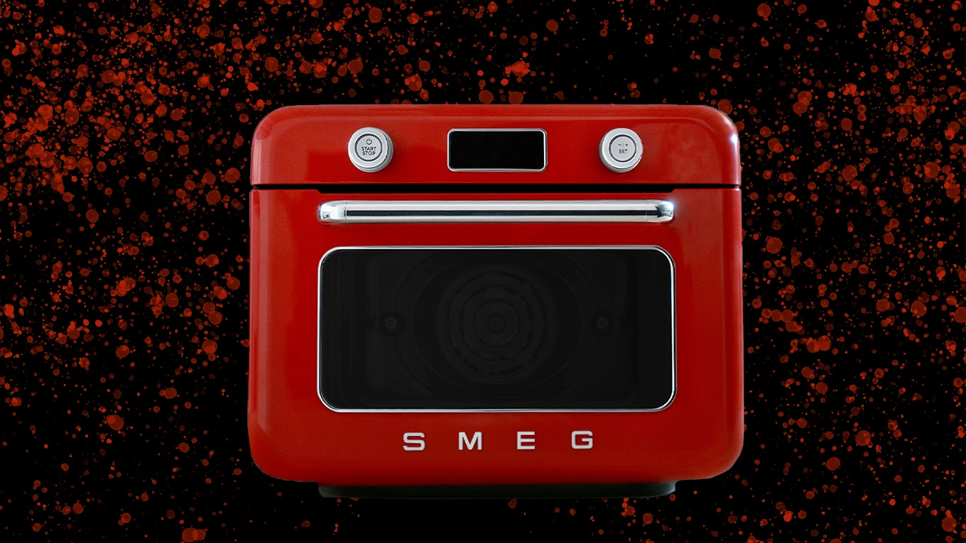 Smeg Mini Dampfbackofen Roter Smeg Mini Dampfbackofen vor schwarzem Hintergrund mit roten Punkten