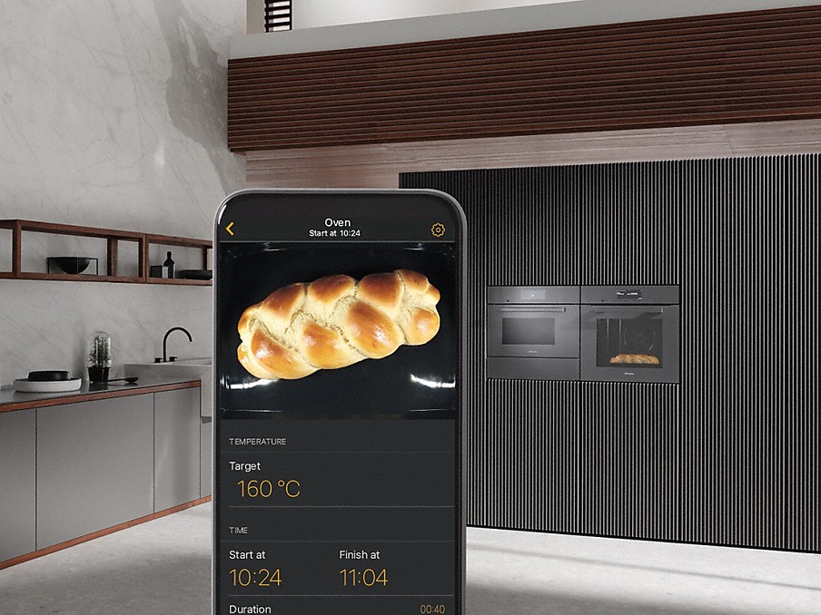 hefezopf mit garangaben auf dem display eines smartphones mit miele app vor einem miele einbau-backofen mit foodview