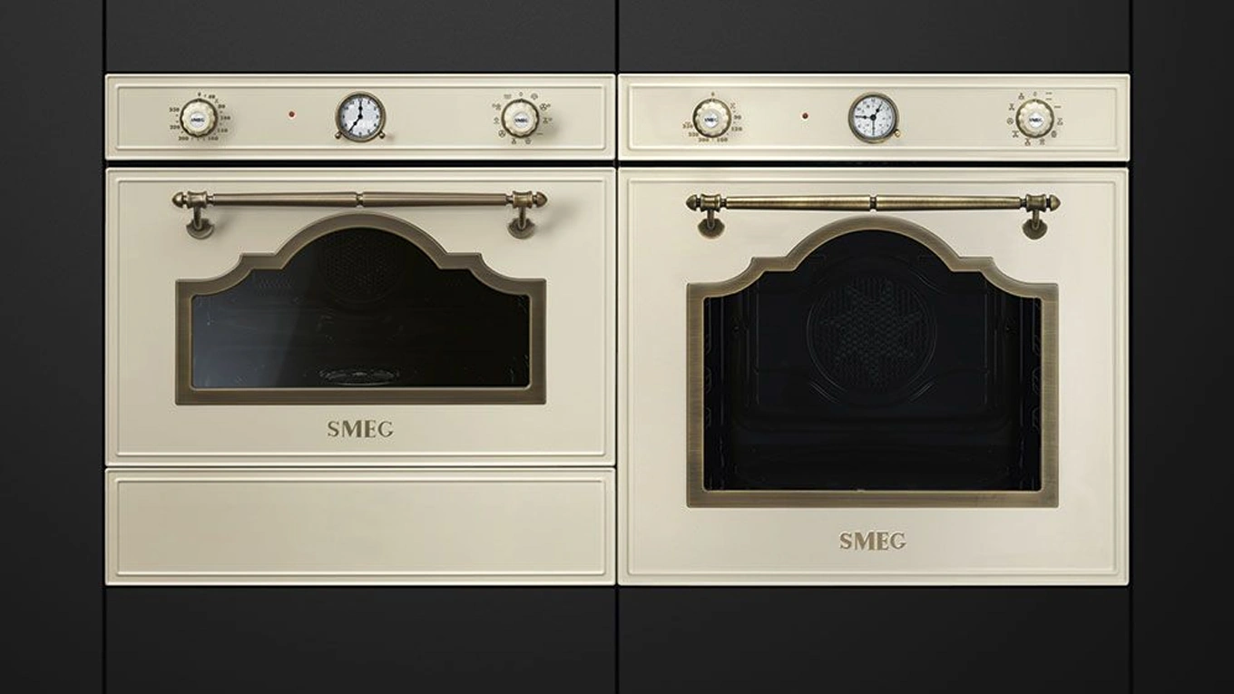 SMEG Cortina Backofen in Creme zwei smeg cortina backöfen in creme mit details in gold in einer schwarzen küchenfront