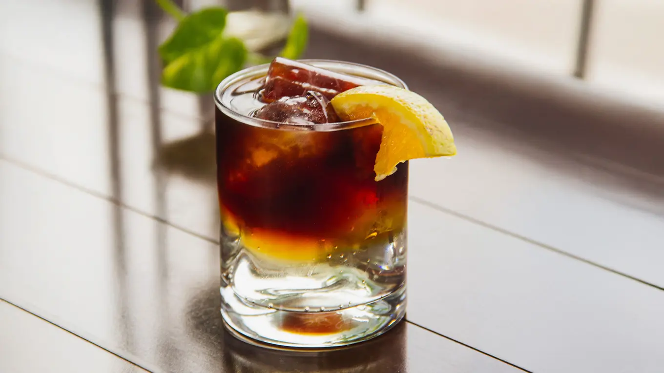 Espresso Tonic mit zitronenscheibe und eiswürfeln auf einem tisch