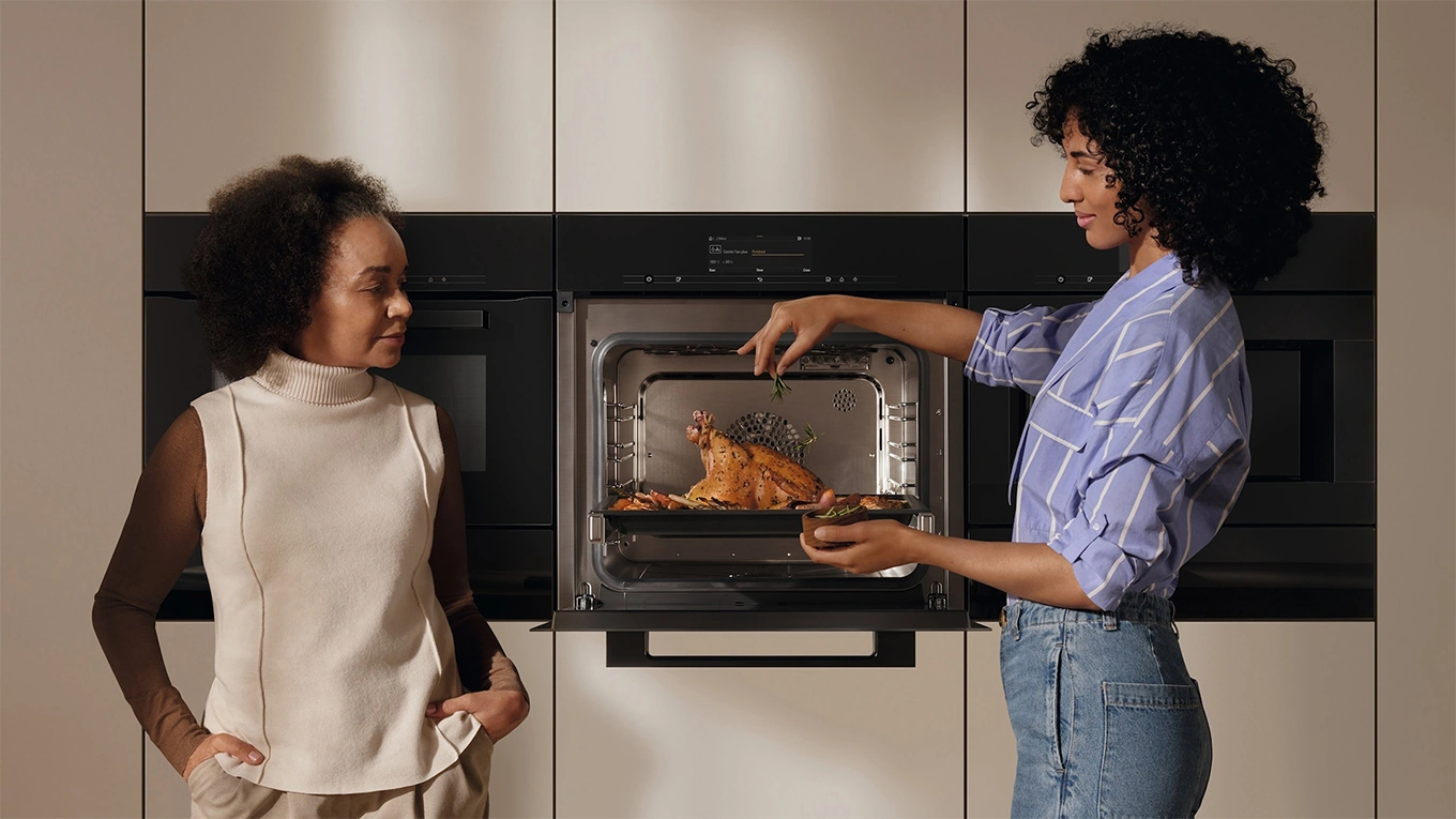 zwei frauen am miele backofen mit speisenthermometer