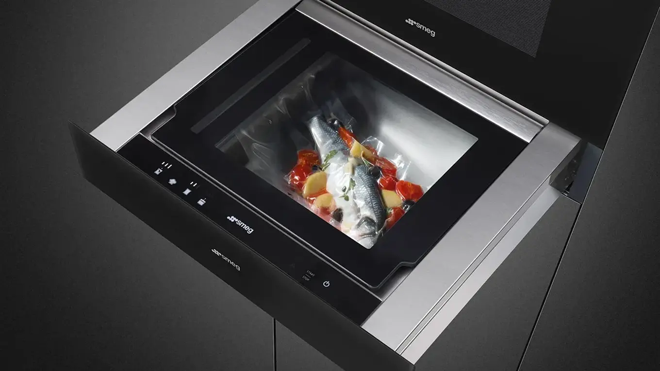 vakuumierter fisch mit gemüse in einem vakuumbeutel in einer smeg vakuumierschublade