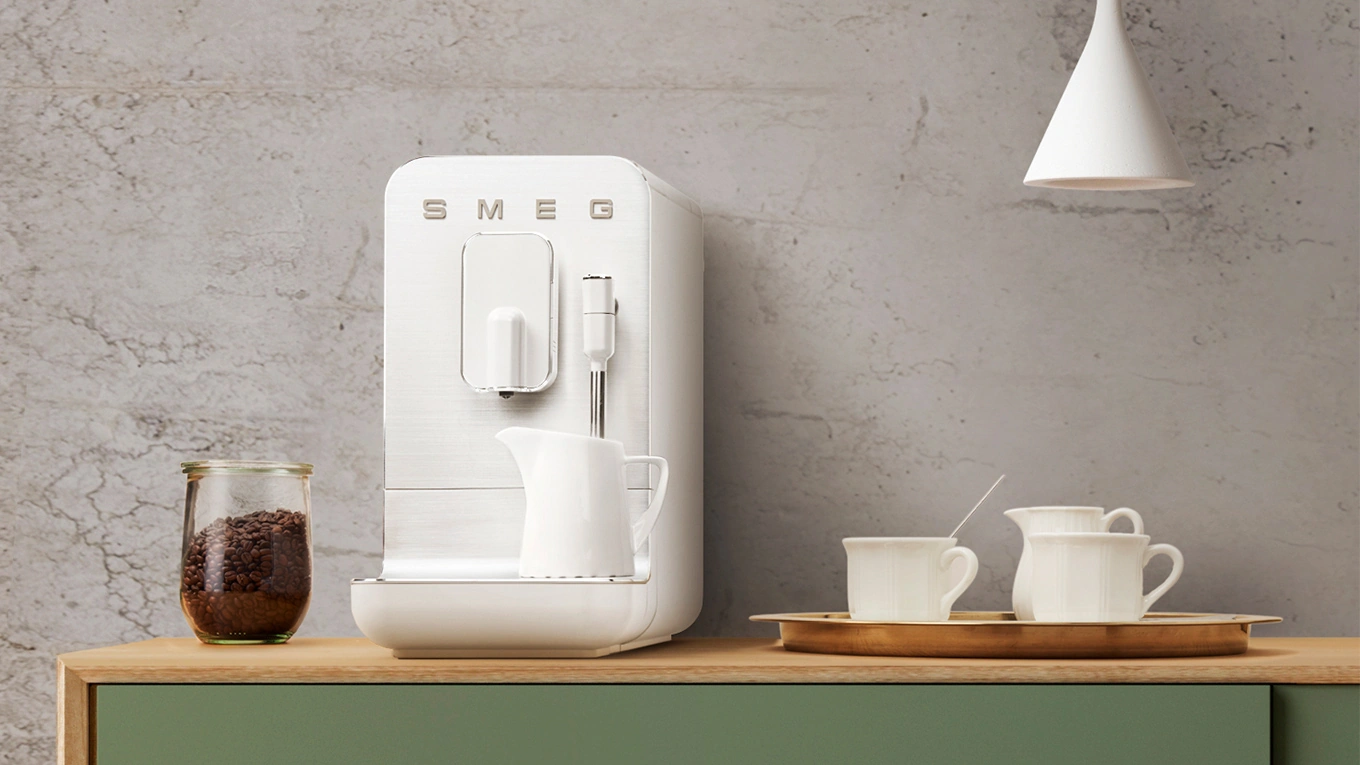 smeg mini kaffeevollautomat in weiß mit Kaffeeservice auf einer arbeitsplatte